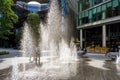 People in London, walking through between the water jets and fountains