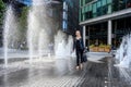 People in London, walking through between the water jets and fountains