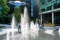 People in London, walking through between the water jets and fountains