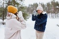 happy man photographing woman in winter forest Royalty Free Stock Photo