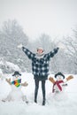 People Love winter. Funny winter girl playing with snow in park on white snow background. Making snowman and winter fun