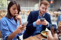 People at lunch distracted from each other by cell phones. not present, social issues, victims of modern technology Royalty Free Stock Photo