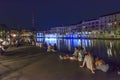 People lying down on embankment at restored Darsena, Milan, Ital