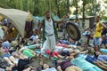 People lying on karemats and meditating, man monk playing musical instrument gong, fest camp. Festival Vedalife. Kyiv