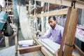 People making colorful silk yarn fabric by Indian weaving loom