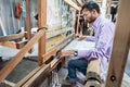 People making colorful silk yarn fabric by Indian weaving loom Royalty Free Stock Photo