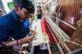 People making colorful silk yarn fabric by Indian weaving loom