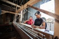 People making colorful silk yarn fabric by Indian weaving loom