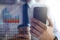 People making money. Businessman using smartphone indoors surrounded by digital charts and dollar signs Royalty Free Stock Photo