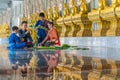 People making rice offerings in front of row of monk statues Royalty Free Stock Photo