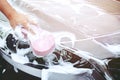 People man holding hand pink sponge for washing car. Concept car wash clean. Royalty Free Stock Photo