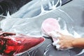 People man holding hand pink sponge for washing car. Concept car wash clean. Royalty Free Stock Photo