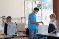 People with masks are using a voting machine in Bulgarian parliamentary elections in Sofia, Bulgaria on July 11, 2021