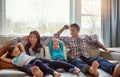 The people that really matter. a happy young family of four relaxing together on the sofa at home. Royalty Free Stock Photo