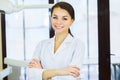 People, medicine, stomatology and healthcare concept - happy young female dentist with tools over medical office background