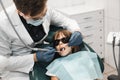 People, medicine, stomatology, technology and health care concept. Male dentist working with little girl in clinic.