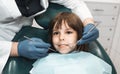 People, medicine, stomatology, technology and health care concept. Male dentist working with little girl in clinic.