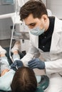 People, medicine, stomatology, technology and health care concept. Male dentist working with little girl in clinic.