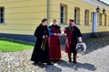 People in medieval clothes, a monk in a cassock, a soldier and a lady