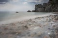 People at Mediterranean beach. Slow motion speed long exposure. Colorful pebbles and silky waves of blue sea on the shore. Royalty Free Stock Photo