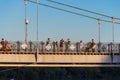 People meet the sunset on the pedestrian bridge in the city park of culture and recreation in the city of Uralsk