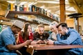 People Meeting Communication Technology Digital Tablet Concept. Group of five multiethnical students sitting in a cafe Royalty Free Stock Photo