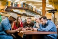 People Meeting Communication Technology Digital Tablet Concept. Group of five multiethnical students sitting in a cafe Royalty Free Stock Photo