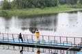 People, men are fishing from the pontoon, apron, bridge on the lake with ducks at the recreation center, sanatoria in the fall