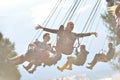 People in merry go round, swing ride, highland spinner