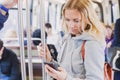 People in metro, commuters, woman passenger looking at the screen of her smartphone Royalty Free Stock Photo