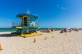 People on Miami beach on beautiful sunny day. Sand beach, tourists and yellow lifeguard tower on blue Atlantic ocean. Royalty Free Stock Photo
