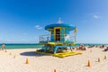 People on Miami beach on beautiful sunny day. Sand beach, tourists and yellow lifeguard tower on blue Atlantic ocean. Royalty Free Stock Photo
