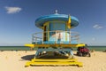 People on Miami beach on beautiful sunny day. Sand beach, tourists and yellow lifeguard tower on blue Atlantic ocean. Royalty Free Stock Photo