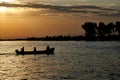 Silhouettes of people in a boat at sunset