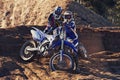 People, motorbike and outdoor by rocks on dirt path with adventure, transportation and extreme sports. Racer, rider and