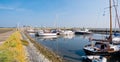 People, motorboats and sailboats in marina of West Frisian island Schiermonnikoog, Netherlands