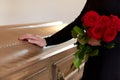 Woman with red roses and coffin at funeral Royalty Free Stock Photo