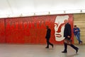 People move past the portrait of the famous poet Mayakovsky, Mayakovskaya metro station