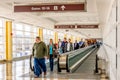 People on a moving walkway in a bright airport