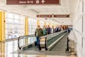 People on a moving walkway in a bright airport