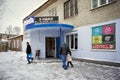 People are near the entrance to the district tax department with an electronic sign with the inscription in Russian