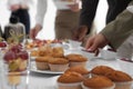 People near table with different delicious snacks during coffee break, closeup