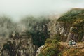 People next to the edge of rocky cliff and mist