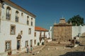 People next to old houses and fountain in baroque style at Marvao