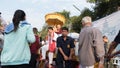 people offering food and items to a buddhist monk and being blessed in temple