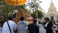 people offering food and items to a buddhist monk and being blessed in temple