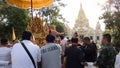 people offering food and items to a buddhist monk and being blessed in temple