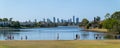 people out on sunny afternoon by city park pond