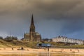 People taking a walk on Tynemouth`s Longsands beach during Lockdown on a cloudy and rainy day, in the north east of England Royalty Free Stock Photo