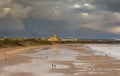 People taking a walk on Tynemouth`s Longsands beach during Lockdown on a cloudy and rainy day, in the north east of England Royalty Free Stock Photo